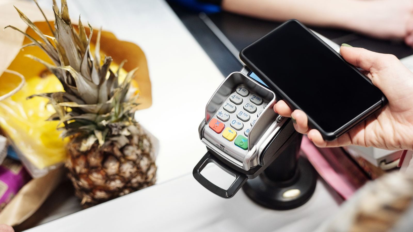 Customer paying contactless with a smartphone at a card terminal