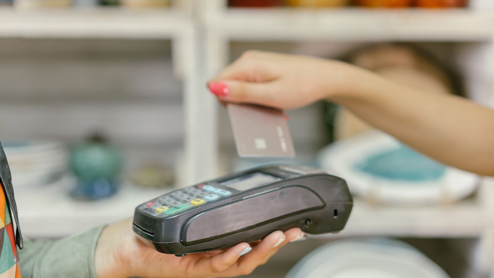 Staff member holding a portable card machine out to a customer